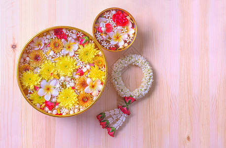 四月美丽的旅游在Songkran节或泰国新年的木本上装饰水碗中的花朵图片
