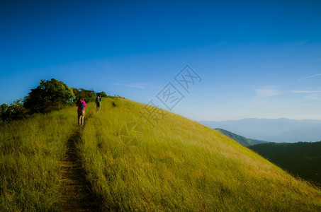 闲暇冒险云背着包站在山顶上的徒步旅行者图片