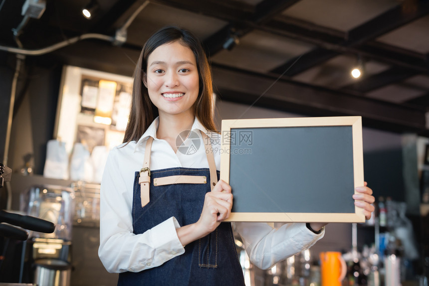 制服快乐的咖啡店内持有空白黑纸板菜单的年轻亚洲女律师协会脸图片