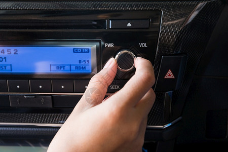 汽车播放器手立体声控制板使用汽车容量音频控制的妇女背景