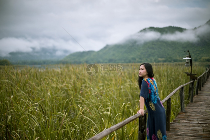 松弛蓝色的木制坐在码头上女人看着日落的美丽图片