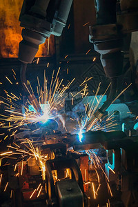 沟通程序团队工业机器人在厂中焊接金属部分建造图片