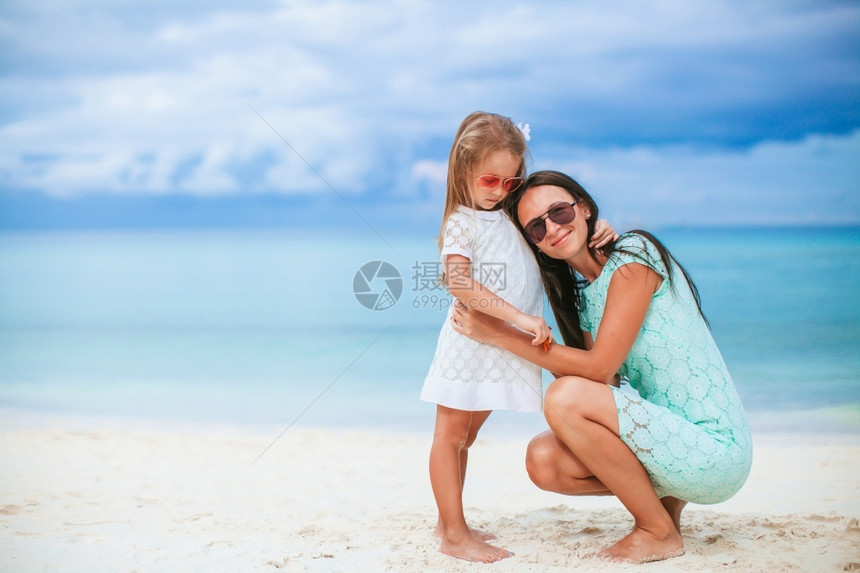 孩子年轻美丽的母亲和她小女儿在海滩上美丽的母亲和女儿在海滩上享受暑假水期图片