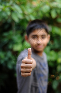 一个英俊的印地安小孩举起拇指来争取成功男打手势的图片