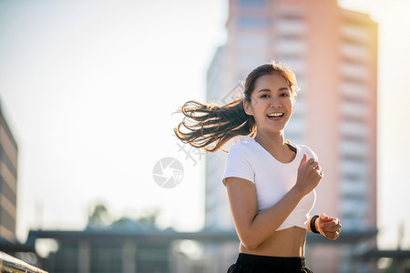 早晨马拉松亚洲青年健身运动女在城市公路上奔跑和微笑人图片