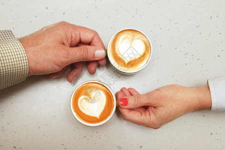 团结香气握着咖啡杯的爱人之手触碰图片