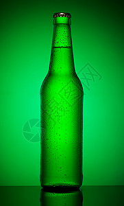 露清爽产品绿色背景的酒瓶冷啤图片
