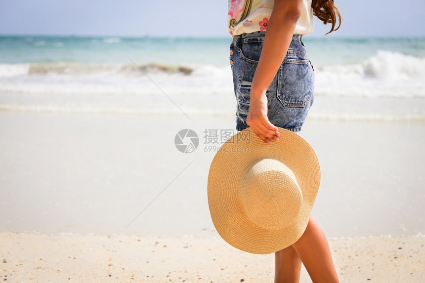 手拿沙滩帽的女人图片