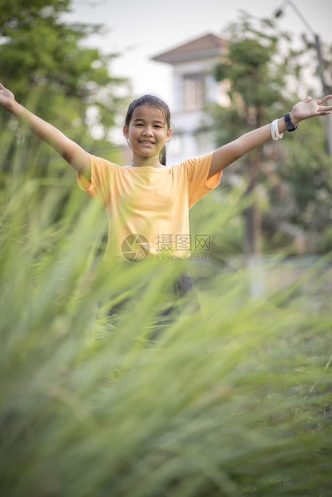 绿色身体可爱的在青绿花园中亚洲青少年手签署胜利的图片