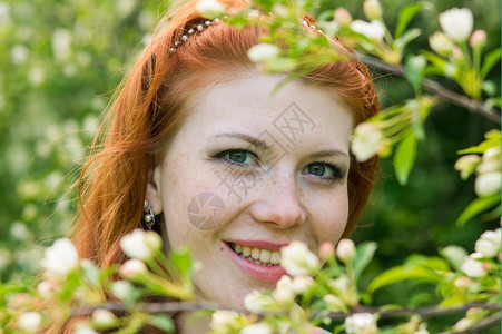 脸可爱的红头发女孩走进苹果园迷人的自然图片