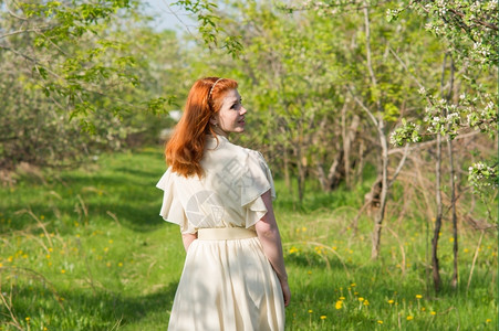 可爱的红头发女孩走进苹果园迷人的时尚美丽图片