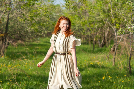 花园奥夫钦尼科草地可爱的红头发女孩走进苹果园图片