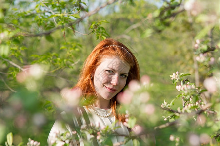 可爱的红头发女孩走进苹果园美丽绿色花图片