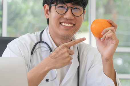 手拿橙子的医生图片