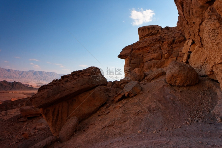 户外美丽的干旱日落时在岩石沙漠中的橙色岩石日落时在头沙漠中遭受风化的橙色岩石图片