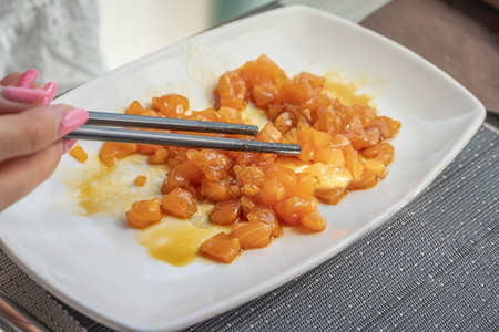 女人用筷子在白菜上吃鲑鱼日本人健康菜单图片