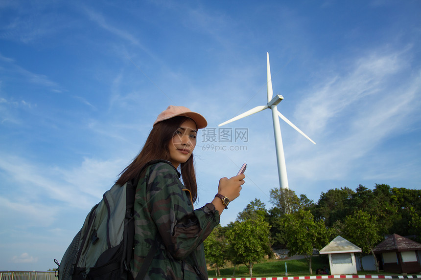 女亚洲人为旅游客和女使用智能手机的背包亮耀斑徒步旅行者景观图片