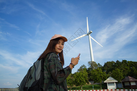 女亚洲人为旅游客和女使用智能手机的背包亮耀斑徒步旅行者景观图片