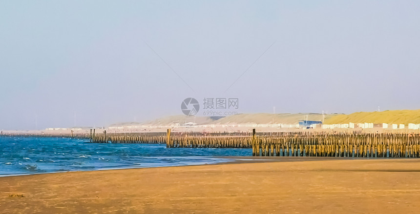 海岸线在多姆堡滩有许多木质的风电杆泽兰和内地旅行游的图片