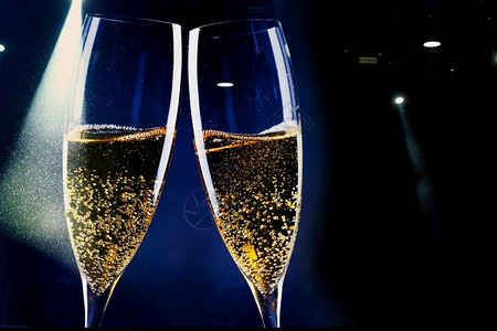明亮的长笛两杯香槟和节假日灯新年庆祝会典金子图片