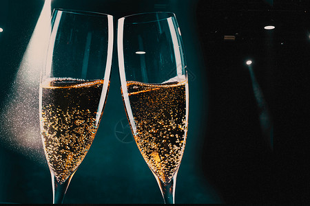 香槟吐司两杯香槟和节假日灯新年庆祝会典眼镜金子玻璃设计图片