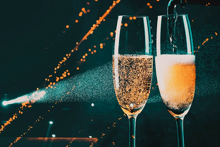 闪亮的喝白色两杯香槟和节假日灯新年庆祝会典图片