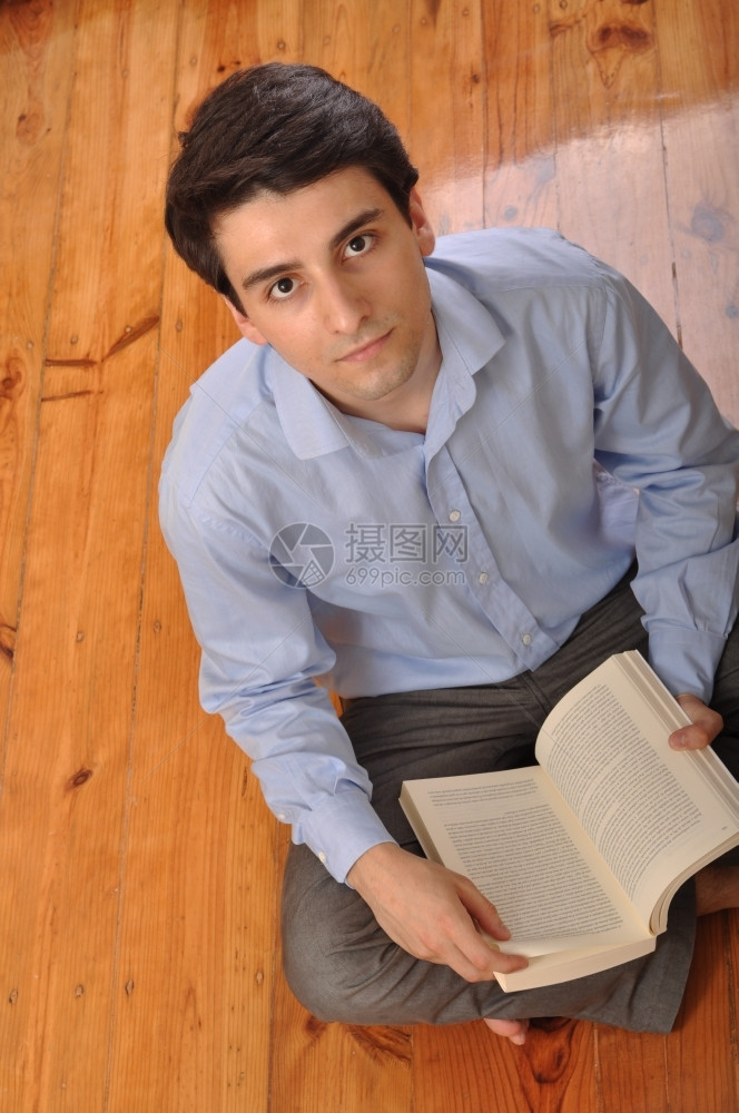 白种人闲暇衬衫在家坐地板上看商业书的有吸引力年轻男青在阅读商业书籍图片