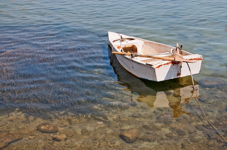 环境的西班牙马略卡岛浅水区停泊的小船与受保护海草波塞多尼斯颜色帆图片