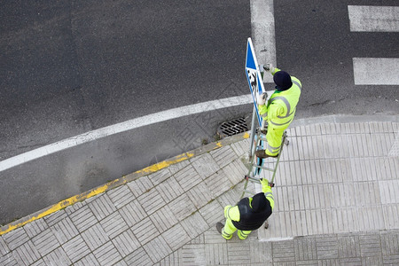 一种人行横道在街上安装新路标的工人公共维护概念上市图片