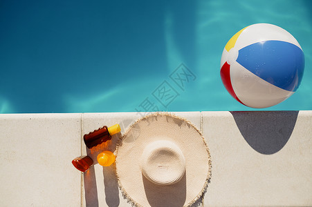 泳池边缘的帽子和充气球图片