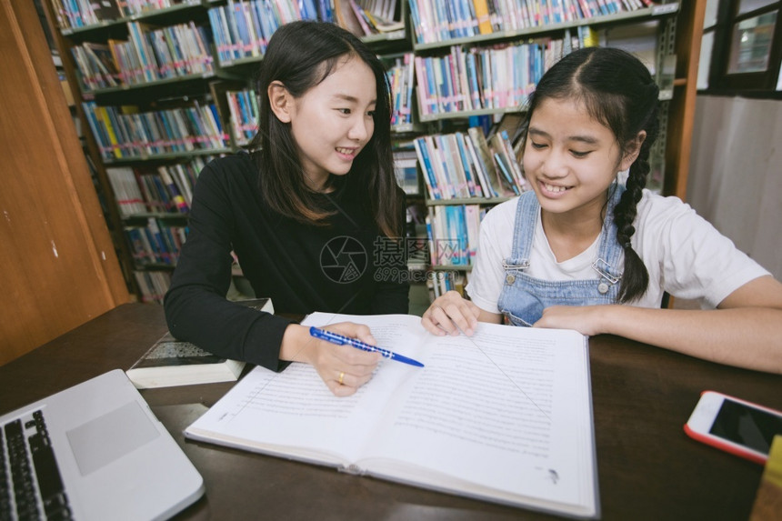 两个亚洲女孩在图书馆讨论学习图片