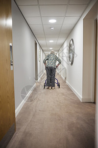 退休后养老院中与行尸走在廊沿线的老年妇女回视大厅孤独90年代图片