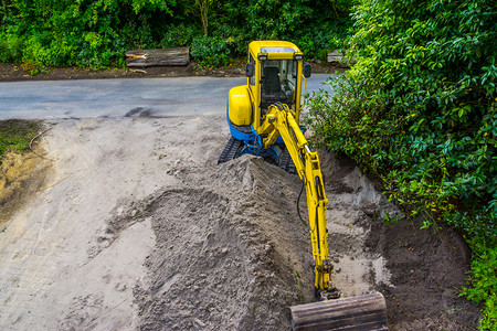 为了花园区堆沙挖土业采掘沙的挖机和移动沙的挖掘机背景图片