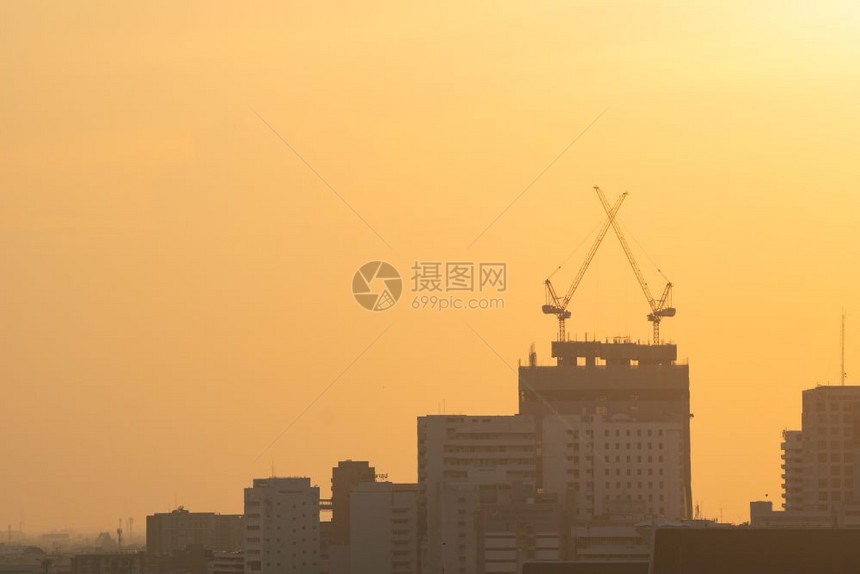日落时建造摩天大楼的起重机植物蓝色的图片