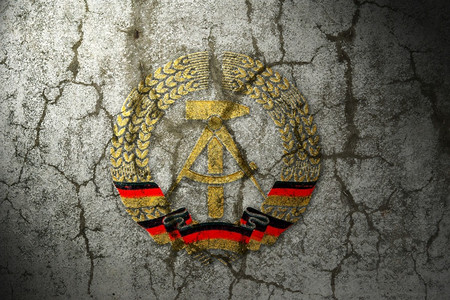 老的德意志民主东德族象征在破碎的墙壁上锤子齐尔克图片