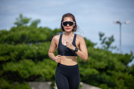 运动员阳光白种人亚裔女在户外城跑步图片