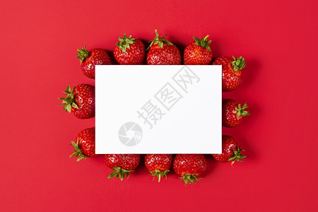 草莓蛋糕店名片夏天红色背景的草莓创意布局与纸卡笔记平躺水果概念食物布局红色背景草莓创意布局与纸卡笔记平躺水果概念食物布局绿色叶子背景