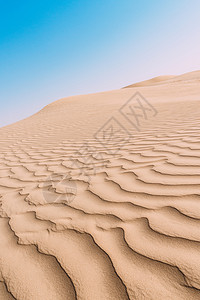 前任的关闭了沙丘表面的顶视图与风形成的起伏波浪模式关闭了沙丘表面的顶视图与风形成的波浪模式质地海滩灰色的设计图片