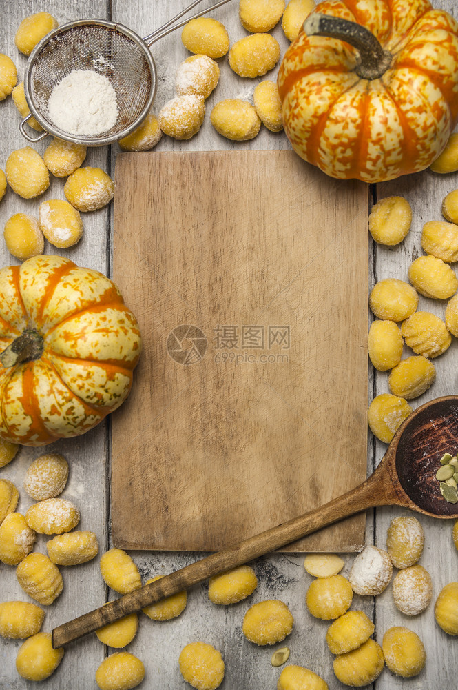 南瓜格诺奇面粉筛选木制勺杏仁南瓜制生锈背景的砍板等成分黄色的生烹饪图片