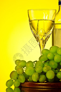 复制空间晚餐金的白葡萄和黄底玻璃红酒和葡萄图片