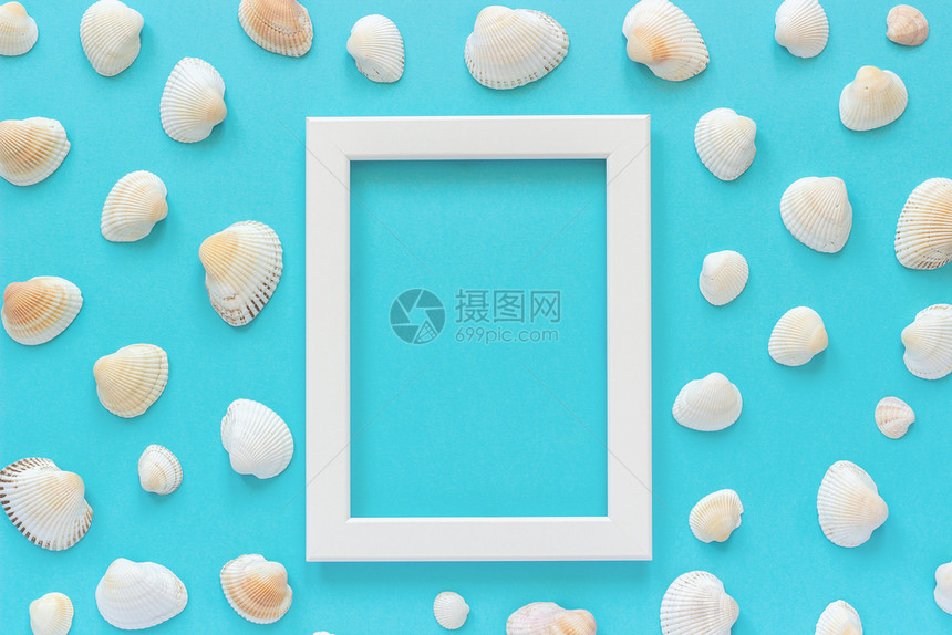 夏天有创造力的蓝色背景和贝壳上带有海星的白框时髦图片
