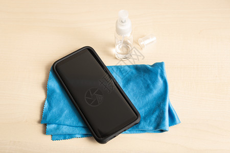 展示桌上手机布和酒精喷雾瓶清洁智能手机概念新冠流感图片