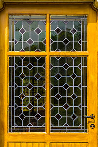 复古的黄色木制门有不同颜色贵重背景的玻璃污点古典图片