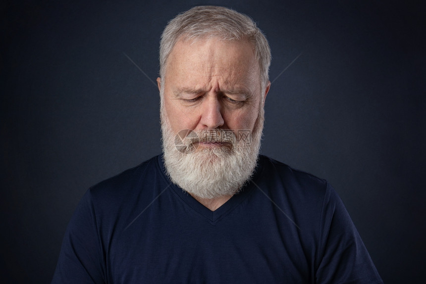 长着灰胡子的老人向下看思考现代的愉快老年图片