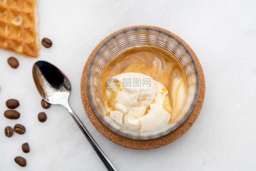 食物奶油的棕色咖啡香草冰淇淋在白大理石桌上的晶玻璃杯中图片