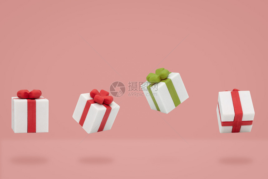 展示快乐的圣诞礼物盒在粉红背景下飞翔构成最小包裹图片