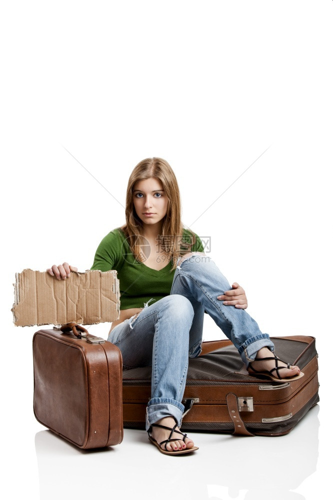 感女孩美丽年轻士坐在旧的手提箱上拿着一张卡片包图片