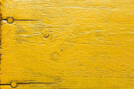 木头粗糙的外部涂漆黄色木桌用钉子作为纹理图片