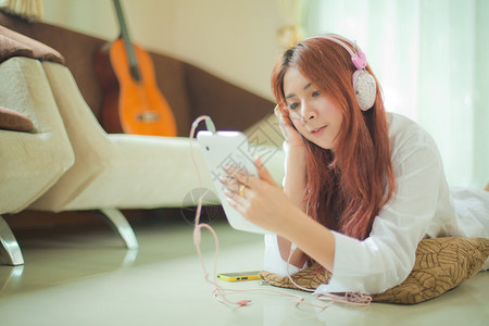 屋聪明的年轻亚洲美丽年轻女拥有智能电话和在家听音乐的聪明女人在室内图片