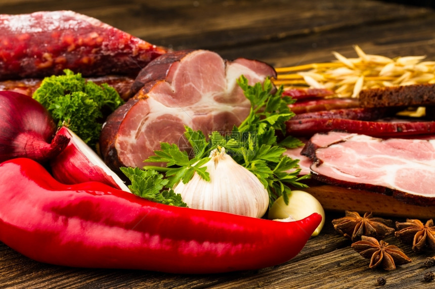 意大利语木制背景的香肠肉蔬菜和香料熟食小吃图片